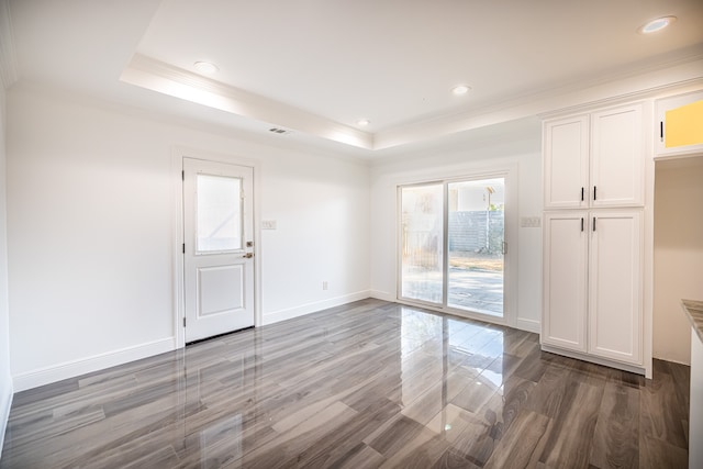 empty room featuring hardwood / wood-style floors, crown molding, and a tray ceiling