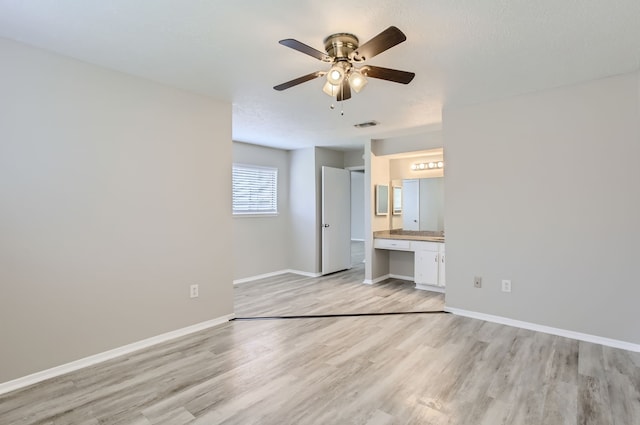 unfurnished bedroom with ensuite bathroom, light wood-type flooring, and ceiling fan