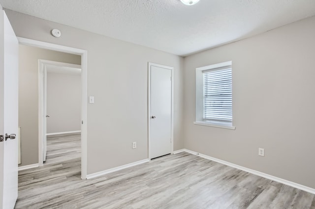 unfurnished bedroom featuring a textured ceiling and light wood-type flooring