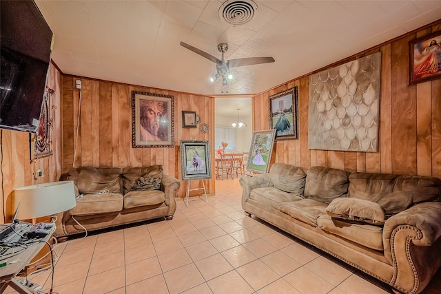 tiled living room with wooden walls and ceiling fan with notable chandelier