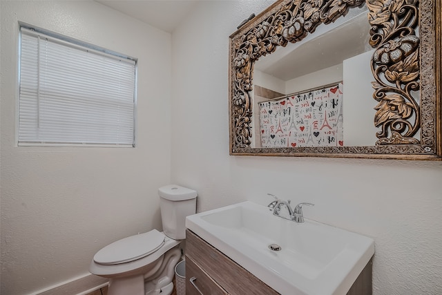 bathroom with vanity, toilet, and walk in shower