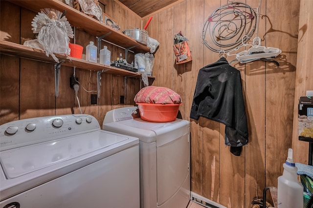 washroom with washer and dryer and wooden walls