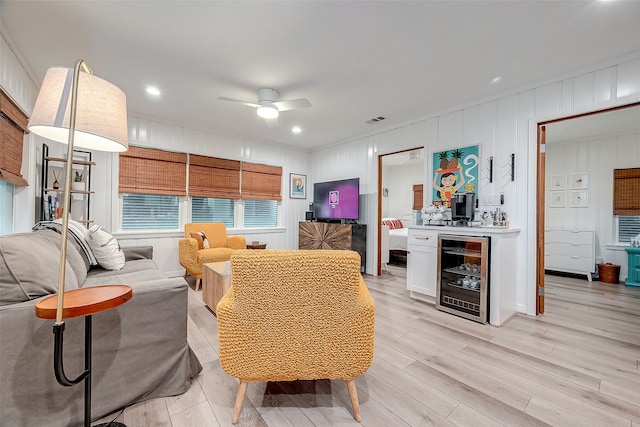 living room with wine cooler, bar, light hardwood / wood-style floors, and ceiling fan