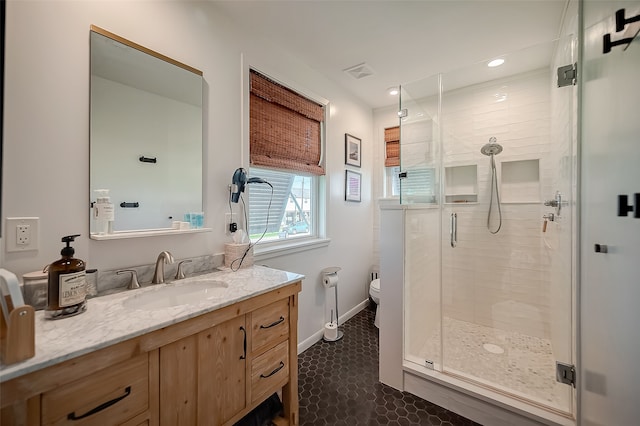 bathroom featuring toilet, walk in shower, vanity, and tile patterned floors