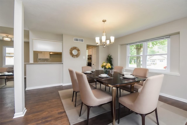 dining space with a chandelier and dark wood-type flooring