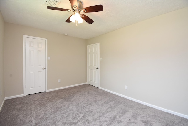 carpeted spare room with ceiling fan