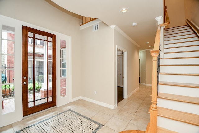 entrance foyer featuring crown molding and light tile patterned floors