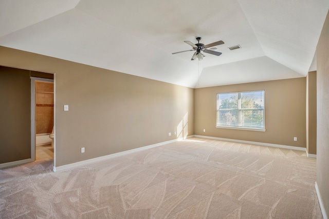 carpeted spare room with ceiling fan and vaulted ceiling