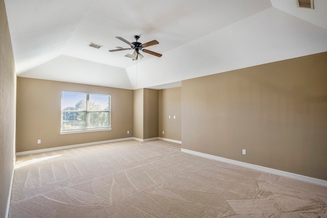 carpeted spare room featuring ceiling fan and vaulted ceiling