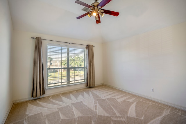 carpeted spare room featuring ceiling fan and vaulted ceiling