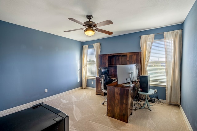 carpeted office with ceiling fan and plenty of natural light