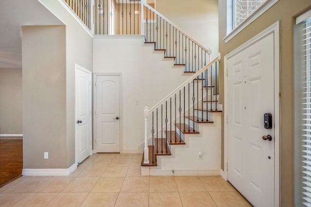 entrance foyer with light tile patterned floors and a high ceiling