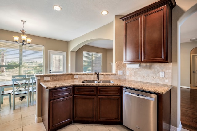 kitchen with kitchen peninsula, sink, a notable chandelier, stainless steel dishwasher, and tasteful backsplash