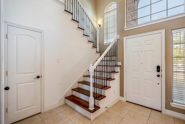 entryway with a high ceiling and light tile patterned flooring