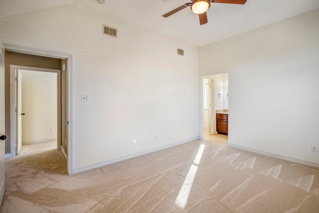 unfurnished bedroom with ceiling fan, ensuite bathroom, and light colored carpet