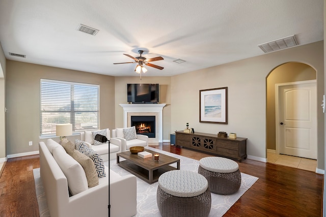 living room with a textured ceiling, hardwood / wood-style flooring, and ceiling fan