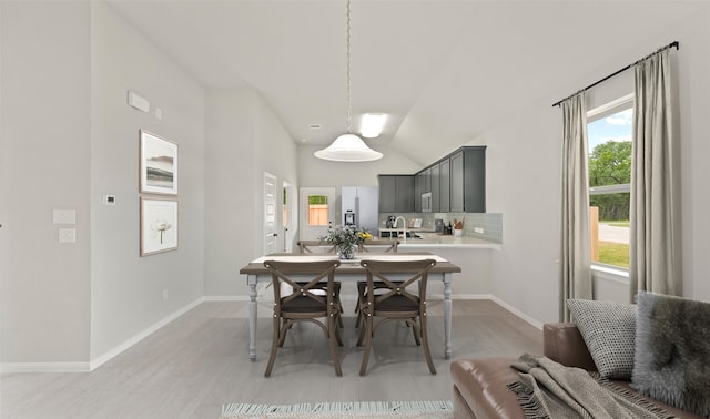 dining space with light hardwood / wood-style flooring and lofted ceiling