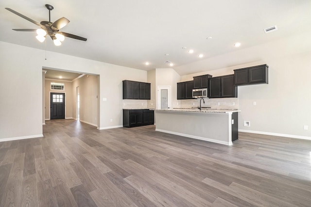 kitchen featuring ceiling fan, sink, an island with sink, and wood-type flooring