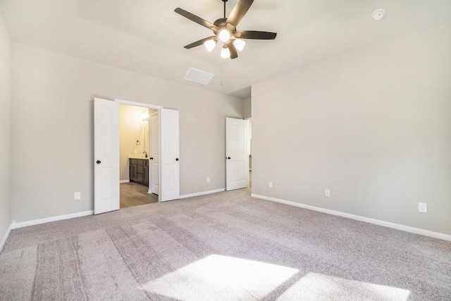 unfurnished bedroom featuring carpet flooring, ceiling fan, and ensuite bath