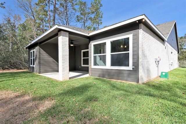 rear view of house featuring a yard, ceiling fan, and a patio area