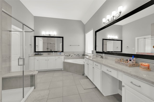 bathroom featuring vanity, vaulted ceiling, separate shower and tub, and tile patterned flooring