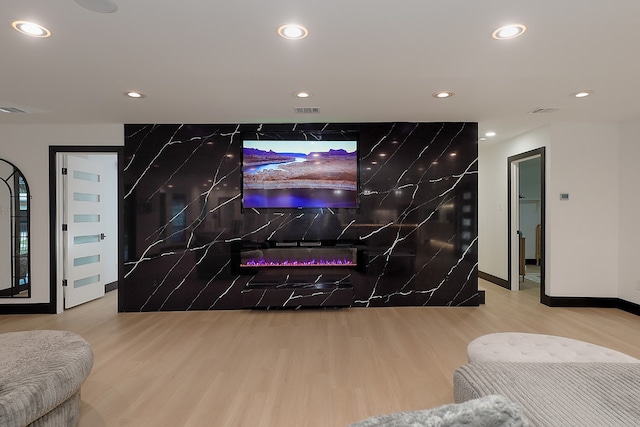 living room featuring a high end fireplace and hardwood / wood-style floors