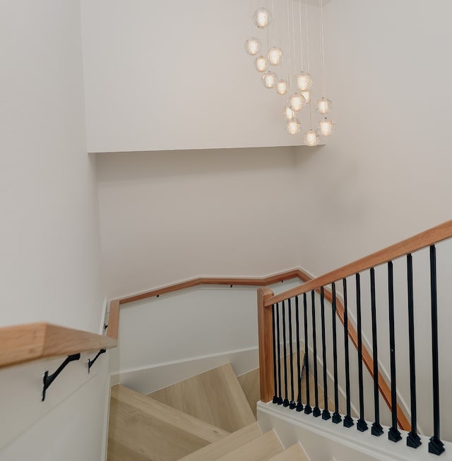 stairs with a notable chandelier