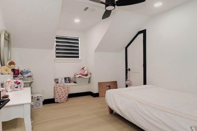 bedroom with light hardwood / wood-style floors, vaulted ceiling, and ceiling fan