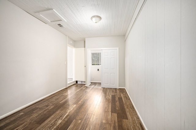 empty room with wooden walls and dark hardwood / wood-style floors