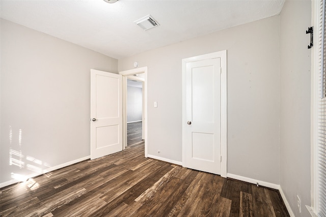 unfurnished bedroom featuring dark hardwood / wood-style floors