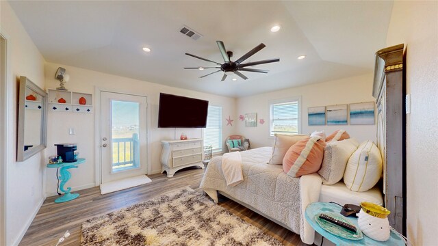 bedroom with ceiling fan, dark hardwood / wood-style flooring, lofted ceiling, and access to exterior