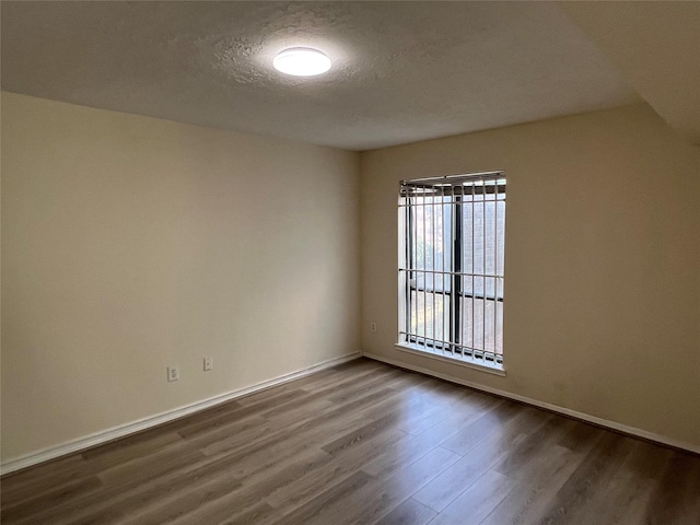 spare room with hardwood / wood-style floors and a textured ceiling