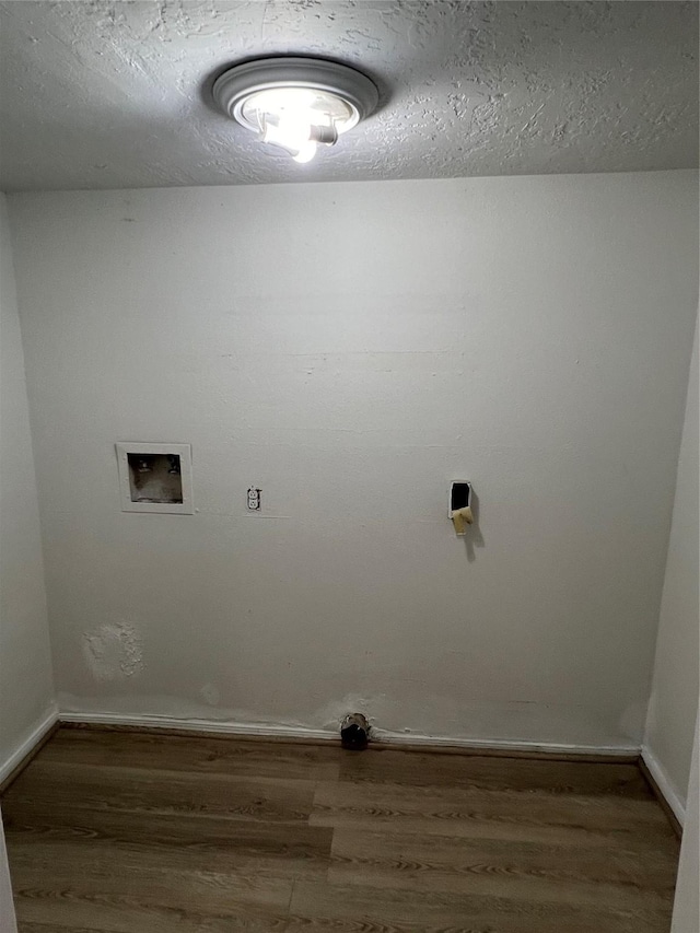 washroom with hookup for a washing machine, dark hardwood / wood-style flooring, and a textured ceiling