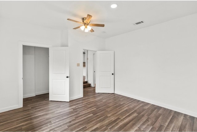 unfurnished bedroom with ceiling fan, dark hardwood / wood-style floors, and a closet