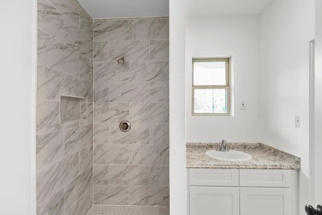 bathroom with vanity and a tile shower