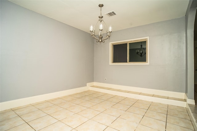 spare room with light tile patterned floors and a chandelier