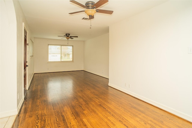 empty room with ceiling fan and dark wood-type flooring