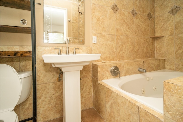 bathroom with tiled bath, tile walls, and toilet