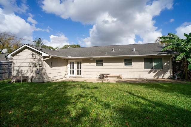 rear view of house featuring a lawn, a patio area, and french doors