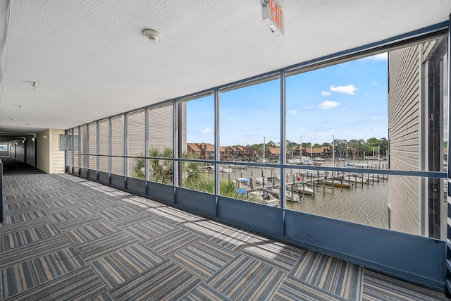 unfurnished sunroom featuring a water view