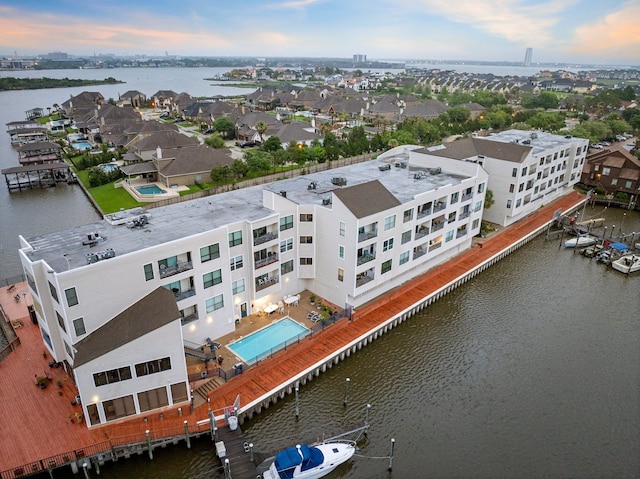 aerial view at dusk featuring a water view