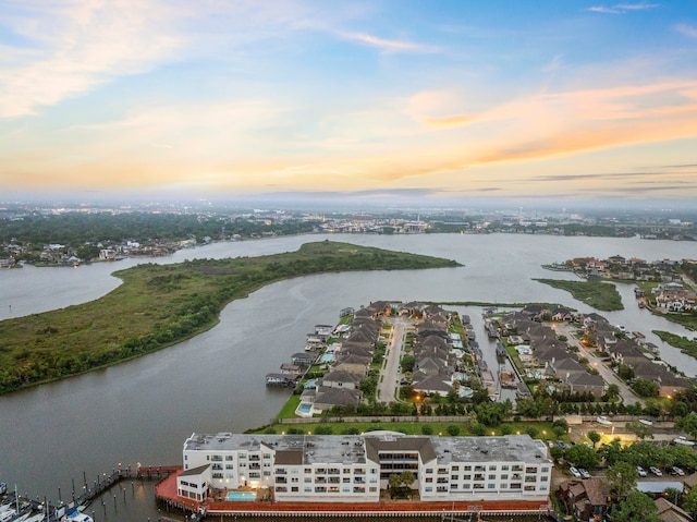 aerial view at dusk featuring a water view