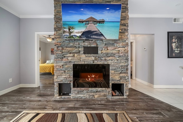 living room featuring crown molding, a fireplace, ceiling fan, and tile patterned flooring