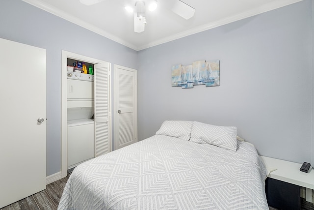 bedroom featuring ceiling fan, crown molding, wood-type flooring, and stacked washer and dryer