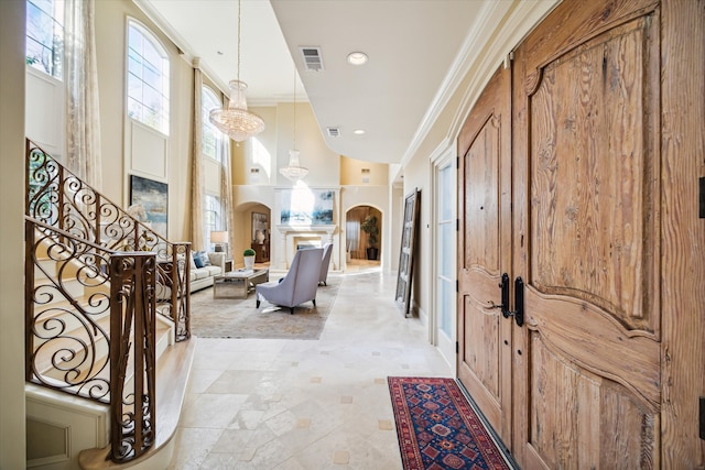 entryway with an inviting chandelier and ornamental molding