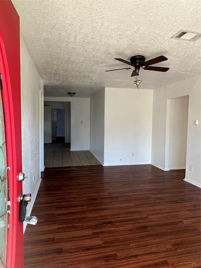 unfurnished room featuring ceiling fan, a textured ceiling, and dark hardwood / wood-style flooring