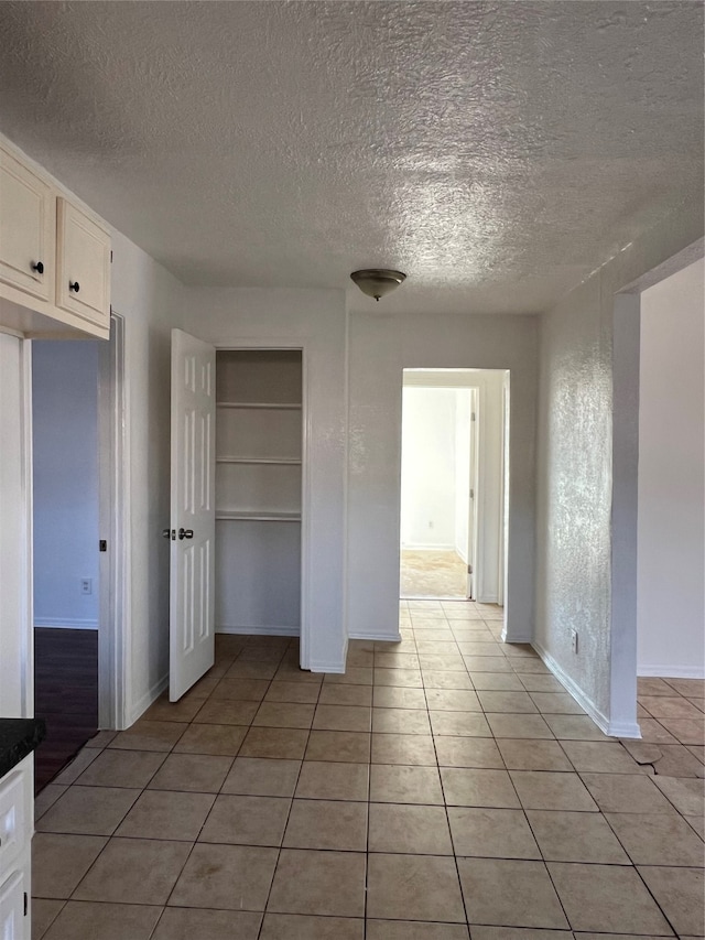 interior space featuring light tile patterned flooring and a textured ceiling