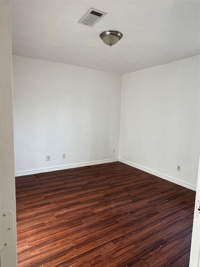 unfurnished room with dark wood-type flooring