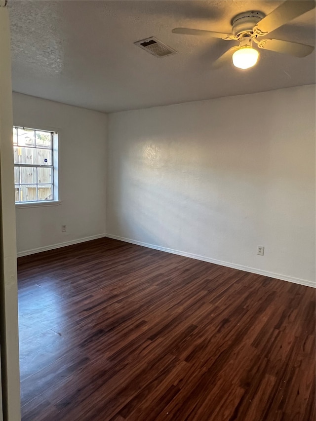 spare room featuring dark hardwood / wood-style floors, a textured ceiling, and ceiling fan