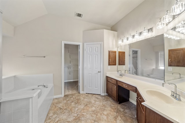 bathroom with vanity, a relaxing tiled tub, tile patterned flooring, and vaulted ceiling